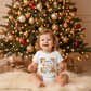 Baby in Thankful for Tiny Miracles onesie by Christmas tree